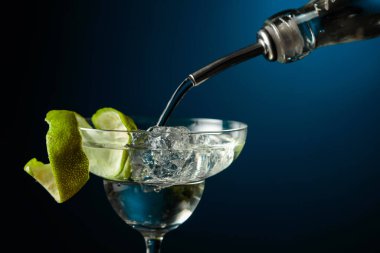 Votka ya da cin buzlu bir bardağa doldurulur. Limon kabuğuyla süslenmiş kokteyl..