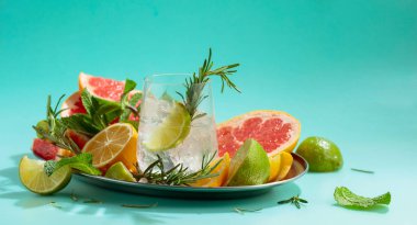 Buz, narenciye, biberiye ve naneli ferahlatıcı bir yaz içeceği. Kopyalama alanı olan yeşil arkaplan.