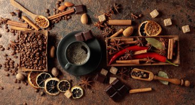 Kahve bazlı aromatik içecekler yapmak için çeşitli baharatlar ve baharatlar. Siyah fincanda sade kahve. Üst görünüm.