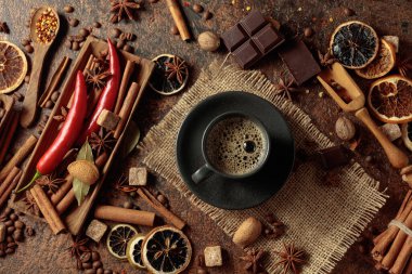 Kahve bazlı aromatik içecekler yapmak için çeşitli baharatlar ve baharatlar. Siyah fincanda sade kahve. Üst görünüm.