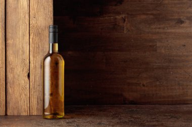 Kaliteli bir arka planda bir şişe beyaz şarap. Vücudu dolgun ve zengin. Metnin ya da markan için boşluk kopyala.