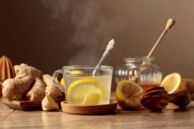 Bej bir mutfak masasında limonlu ve ballı zencefil çayı. Boşluğu kopyala.