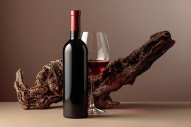 Bej arka planda yıpranmış eski bir pürüz olan bir şişe ve bir bardak kırmızı şarap. Boşluğu kopyala.