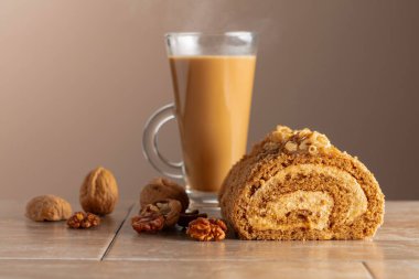 Ceviz ve tereyağlı krema: Geleneksel bir Doğu hamur işi. Cevizli tatlı ve bej arka planda kahve. Kahverengi şeker, ceviz ve kremalı kek. Boşluğu kopyala.