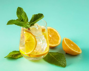 Buzlu, limonlu ve naneli yaz ferahlatıcı içecek. Kopyalamak için yeşil arkaplan.