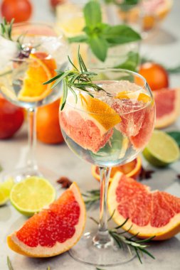 Beyaz mermer bir masada turunçgil ile yaz kokteyllerini tazeliyorum. Buzlu, biberiyeli ve naneli. Seçici odak.