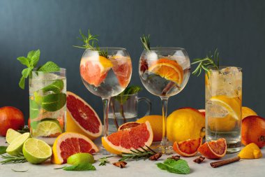 Beyaz mermer bir masada malzemelerle yaz içeceklerini tazeliyorum. Limonlu çeşitli kokteyller..