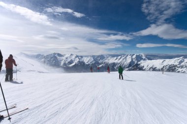 Kış kayak merkezinin yamaçlarında kayakçılar, Fransız Alpleri