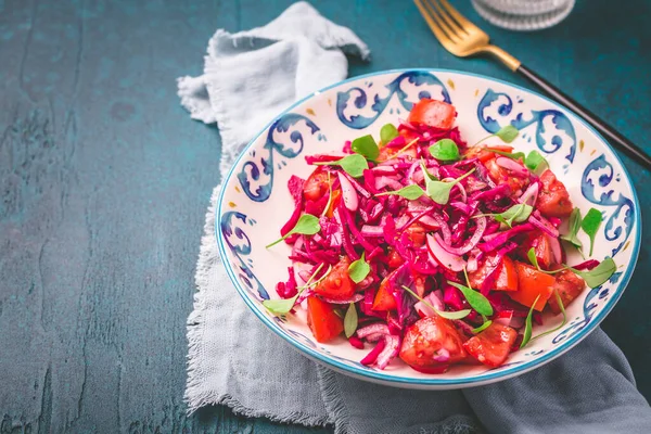 Winter salad - pickled red cabbage salad with radish, tomatoes, onion and  winter purslane. Vegetarian healthy food.