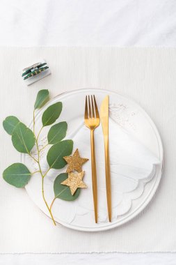 Noel sofrasında beyaz tonda çatal bıçak takımı.