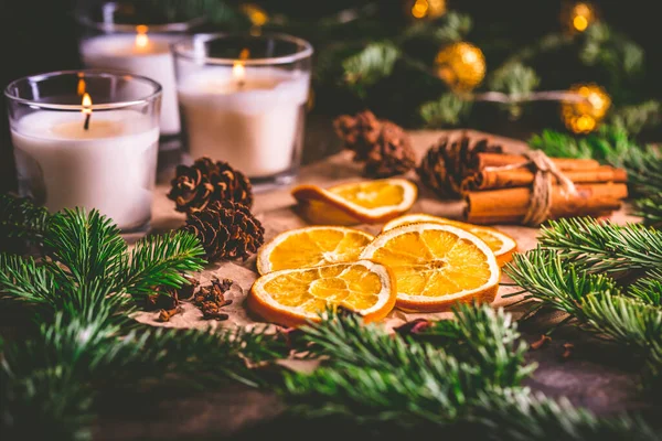 Gedroogde Sinaasappel Kerstkruiden Met Takken Van Kerstboom Kaneel Kaarsen Keukentafel — Stockfoto