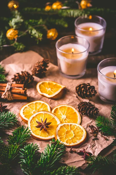 Szárított Narancs Karácsonyi Fűszerek Karácsonyfa Ágaival Fahéjjal Gyertyákkal Konyhaasztalon — Stock Fotó