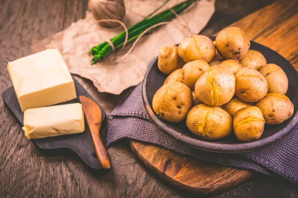 Gekochte Junge Kartoffeln Mit Butter Und Schnittlauch Auf Schneidebrett — Stockfoto
