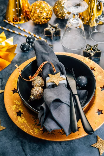 大晦日とクリスマスのためのモダンなプレートと華やかな黒と金の場所の設定 — ストック写真