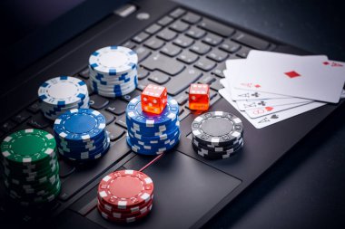 Çevrimiçi poker. Cips, kart ve zarlar klavyenin yanında. İnternetteki bahis hizmetleri. Web sitesinde kumar oynamak ve para kazanmak. Evde çevrimiçi poker oyna.