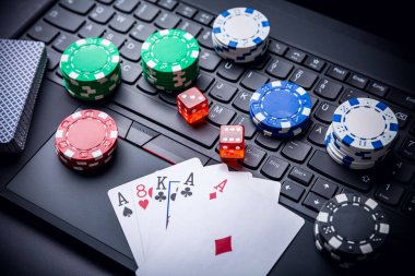 Çevrimiçi poker. Cips, kart ve zarlar klavyenin yanında. İnternetteki bahis hizmetleri. Web sitesinde kumar oynamak ve para kazanmak. Evde çevrimiçi poker oyna.