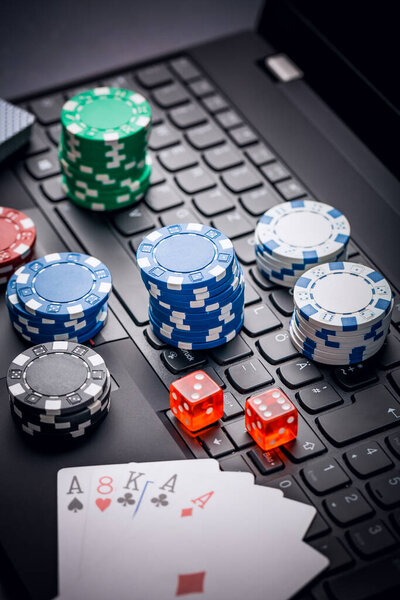 Online poker. Chips, cards and dice nearby keyboard. Betting services on Internet. Gambling on website and winning money. Play poker online at home.