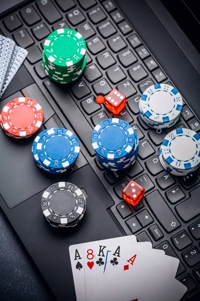 Online poker. Chips, cards and dice nearby keyboard. Betting services on Internet. Gambling on website and winning money. Play poker online at home.