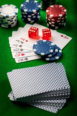 Playing cards, dice and poker chips , casino poker chips on green background