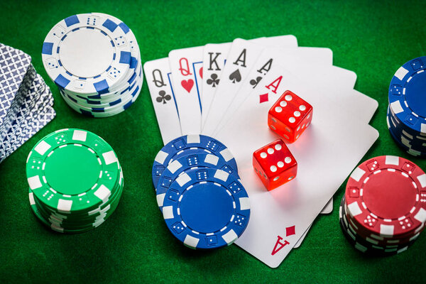 Playing cards, dice and poker chips , casino poker chips on green background