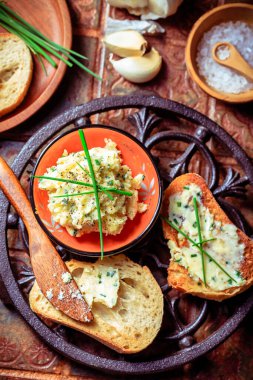 Homemade garlic bread or baguette slices with garlic butter and herbs on kitchen table