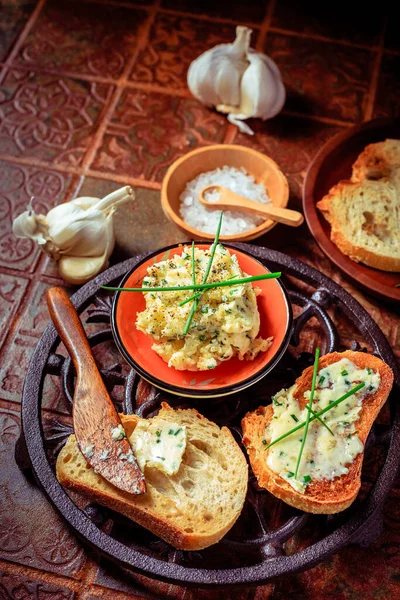 Homemade garlic bread or baguette slices with garlic butter and herbs on kitchen table