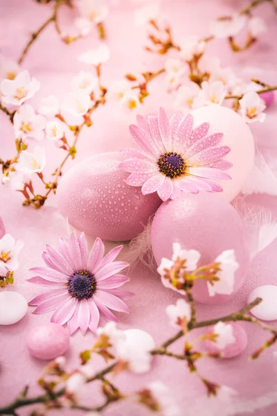 Easter eggs and pink flowers on pink background. Easter, and spring concept