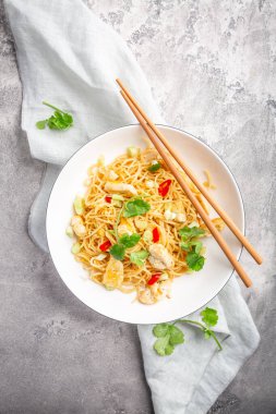Stir fried noodles with chicken and vegetable in white bowl. Asian style food.