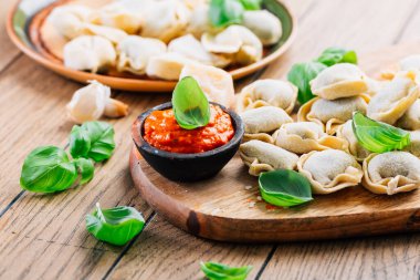 Home cooking - raw tortellini pasta with tomato pesto and sun-dried tomatoes and basil