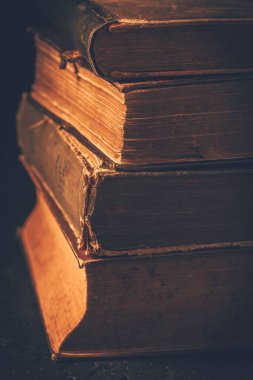 Vintage books stack on old wooden surface, selective focus