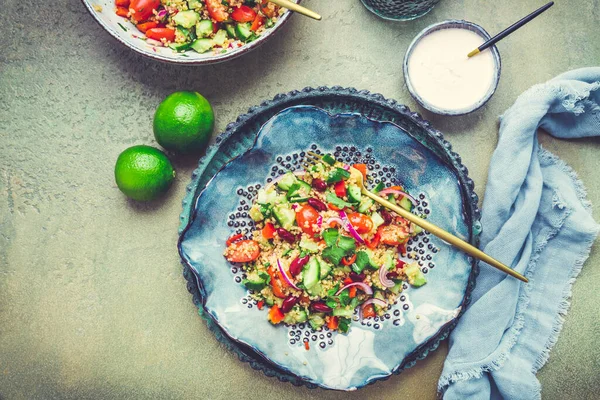 Healthy quinoa black bean salad with fresh tomatoes, cucumbers, onion and cilantro