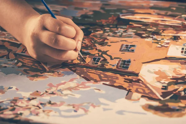 キャンバスにアクリル絵具で田舎の筆描きの絵を描いた手 アートコンセプト — ストック写真