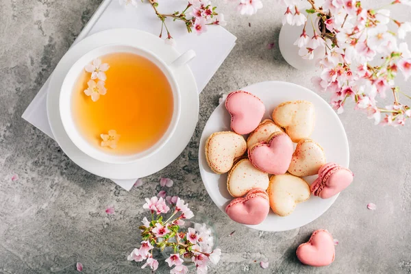 お母さんのための桜の花びらを持つ茶と心の形をしたマカロンまたはフランスのマカロン日 — ストック写真