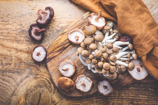 まな板に生の茶色のしめじと椎茸 食用キノコ — ストック写真