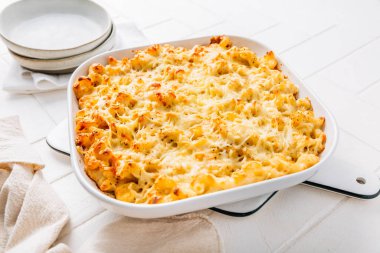 Mutfak masasında güveçte makarna ve peynir.