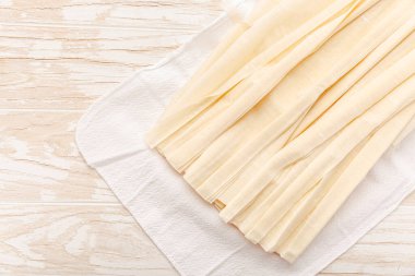 Raw phyllo pastry, thin filo dough for baking, for pie and cakes on wooden kitchen table clipart