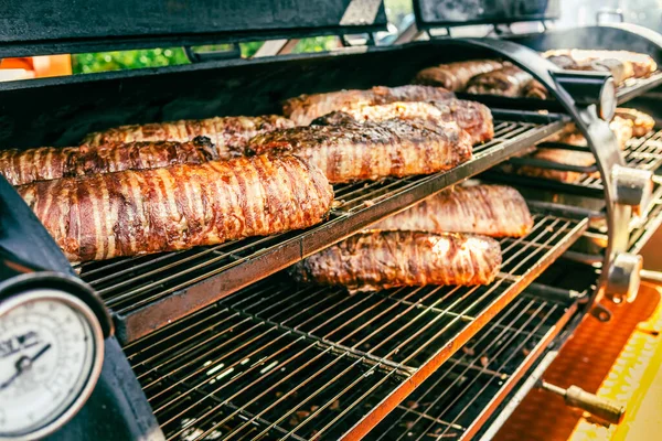 公園で大きなバーベキュー喫煙者グリル バーベキュースモーカーで調理された肉とベーコン — ストック写真