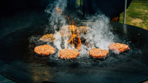 ジューシーな牛肉のハンバーガーのパテを準備します 熱い炎の上に焼けるバーベキュー肉 — ストック写真