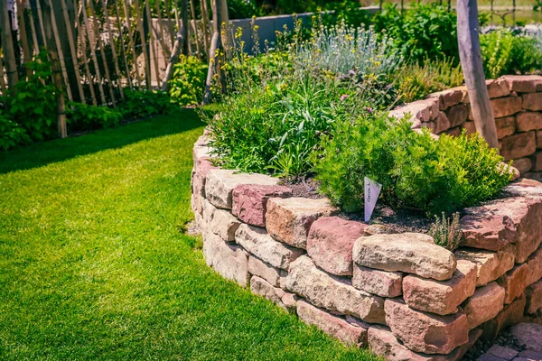 緑の芝生の小さな庭のためのレンガで作られたハーブのスパイラル — ストック写真