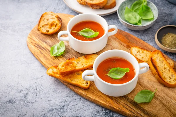 自制番茄汤 用罗勒 吐司和橄榄油装饰在木板上 — 图库照片