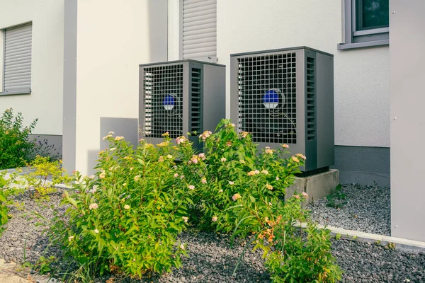 Modern air source heat pumps installed outside of new and modern city house, green renewable energy concept of heat pump