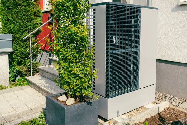 Modern air source heat pump installed outside of new city house, green renewable energy concept of heat pump