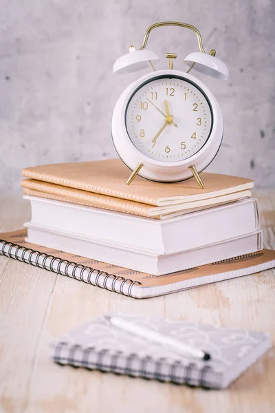 Alarm clock and books - time management and procrastination concept