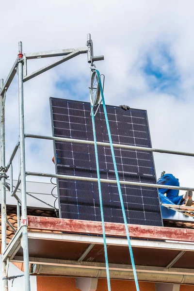 用滑轮升起太阳能电池板 在屋顶上安装太阳能电池板 屋顶上的太阳能电池板安装太阳能电池的工人 — 图库照片