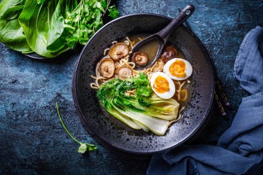 Miso ramen Asya eriştesi çorbası Shiitake, yumurta ve pak choi lahana ile koyu arkaplanda