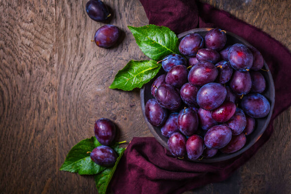 Свежие сливы на темном деревянном фоне