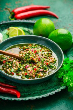 Çiğ Arjantin yeşil Chimichurri ya da Chimmichurri salsası ya da maydanoz, kişniş, biber, sarımsak, kekik, zeytinyağı ve kırmızı şarap sirkesinden yapılan sos.
