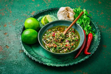 Çiğ Arjantin yeşil Chimichurri ya da Chimmichurri salsası ya da maydanoz, kişniş, biber, sarımsak, kekik, zeytinyağı ve kırmızı şarap sirkesinden yapılan sos.