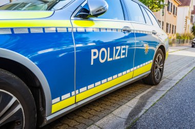 Sokakta Alman polis arabası. Polis arabasının yan görüntüsü. Üzerinde polis yazıları var. Polis devriyesi arabası park etmiş. Çevirisi: Polis 