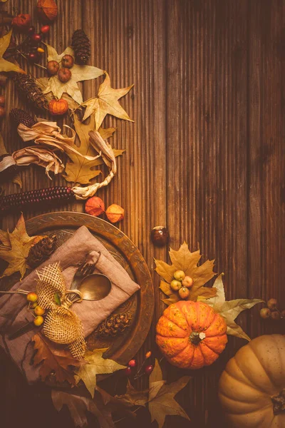 Autumn and Thanksgiving background with pumpkins and autumn leaves, place setting.